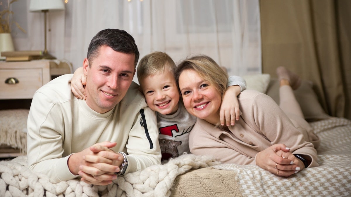 a man and woman with a couple of children on a bed